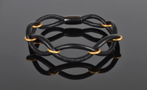 Armbånd i sort Kobe kalveskind med mat forgyldte Sterling sølvringe.Med sort rhodineret magnetlås. Tykkelse 3,5 mm.